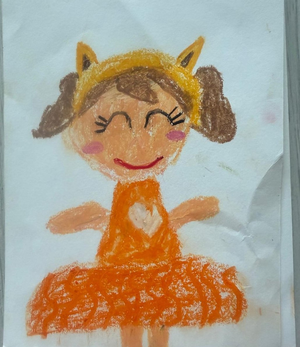 Mrs. Foxy — a smiling doll with brown pigtails, a yellow fox-ear headband, and an orange dress — oil pastel drawing by Aahana